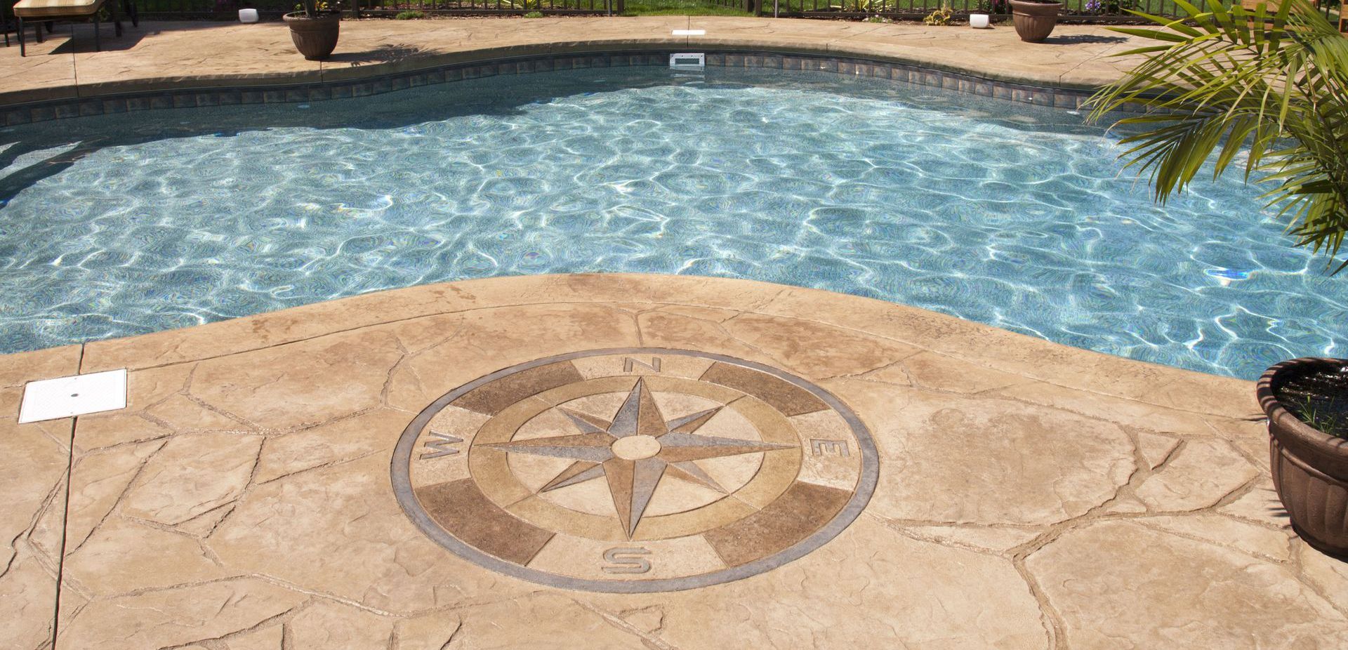 Pool with a compass rose design in the concrete patio.