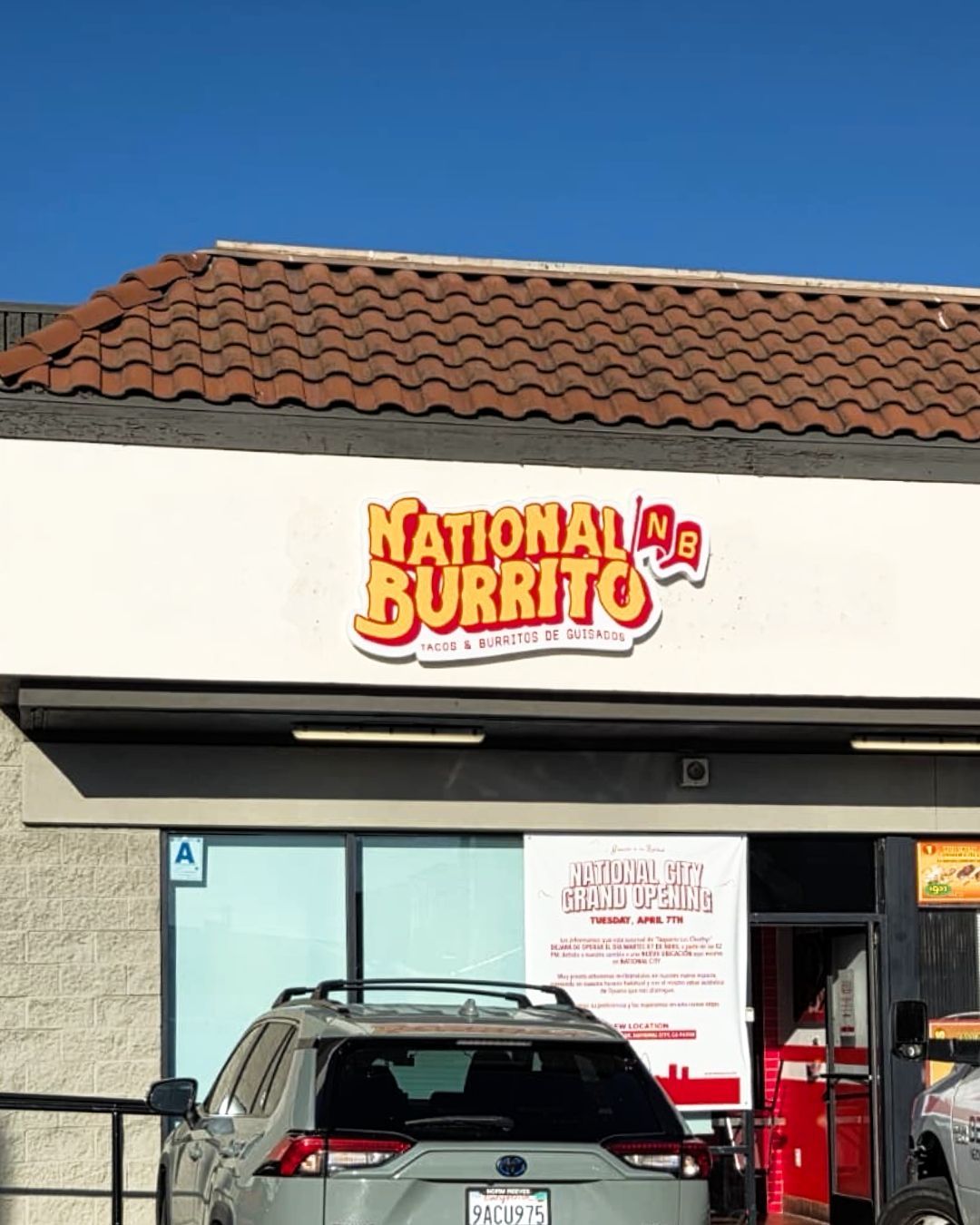 National Burrito restaurant storefront with a tan roof and parked cars in front