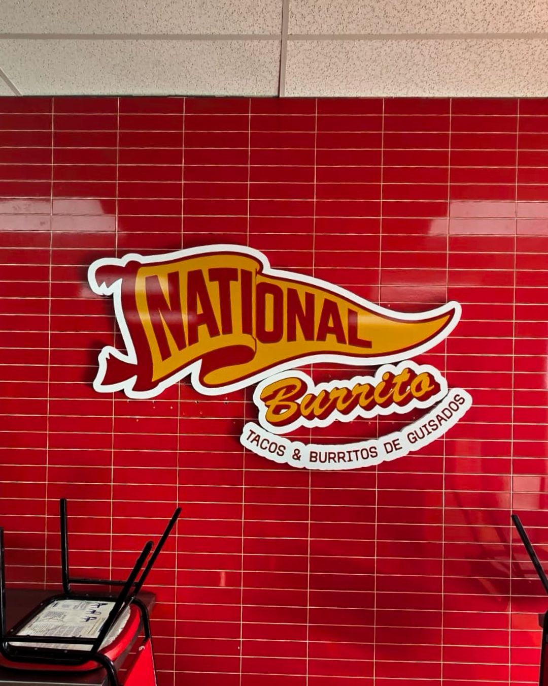 National Burrito logo on a red tiled wall in a restaurant