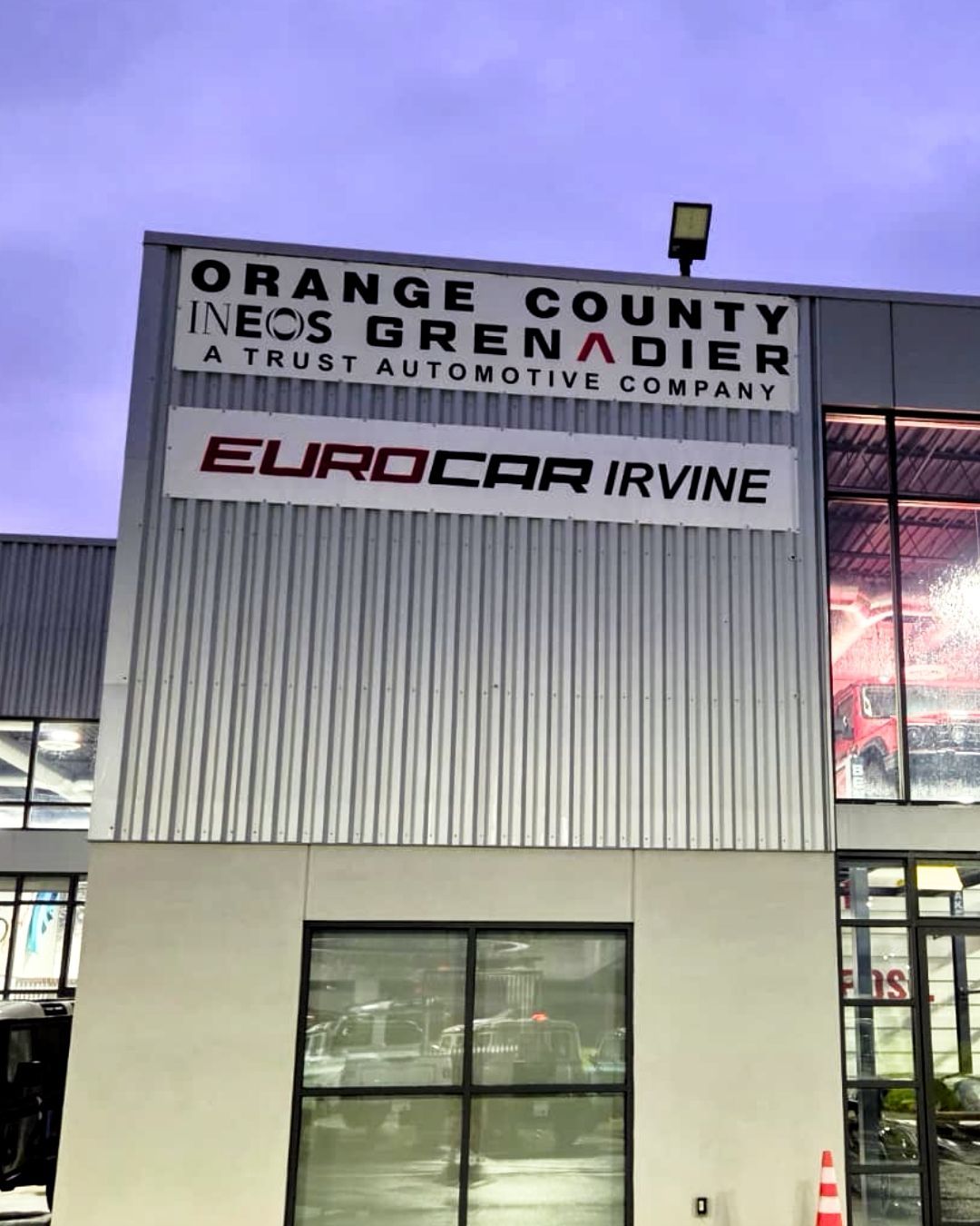 Orange County Neighbors/Grenier Auto body sign above EuroCar Irvine building at dusk