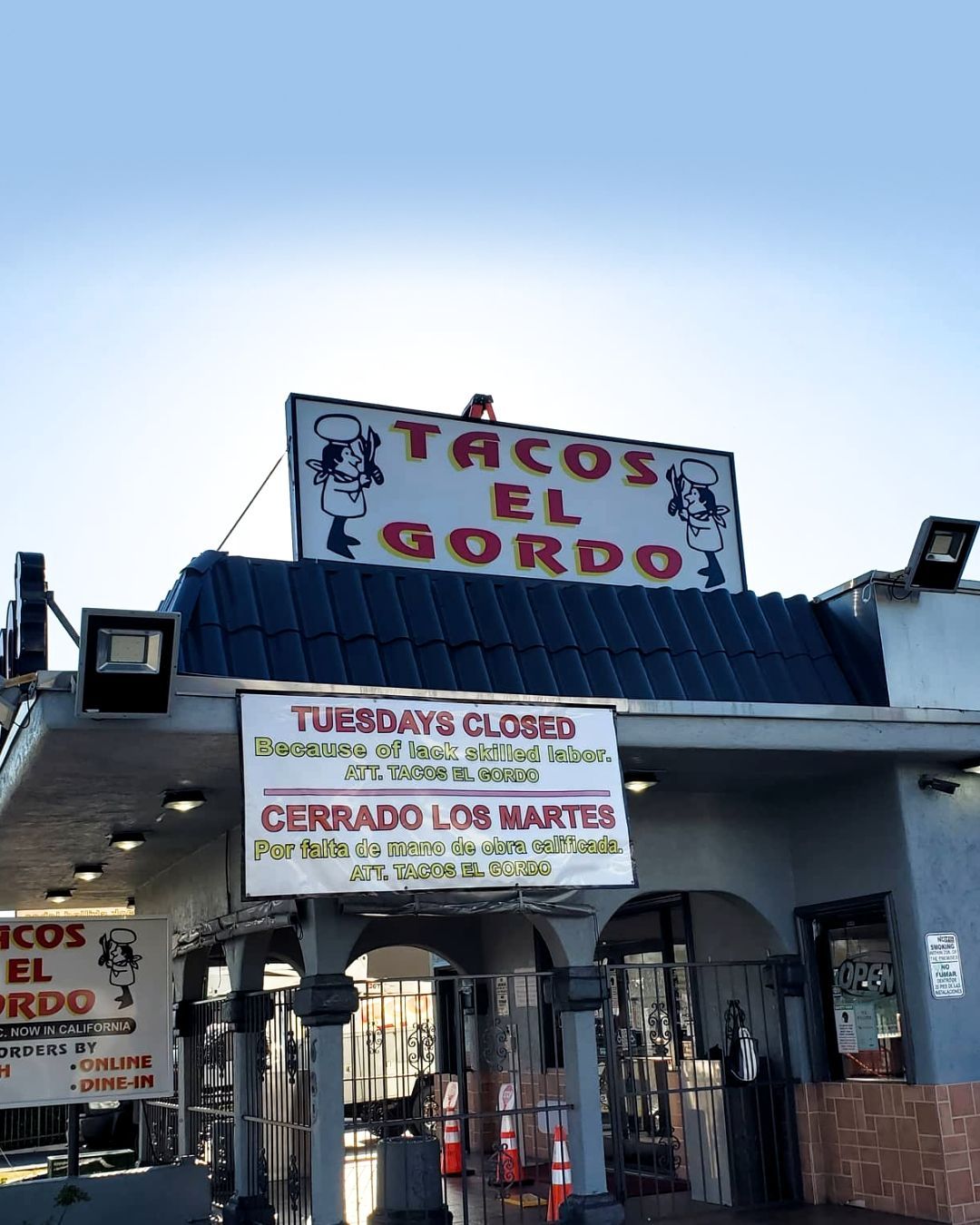 Taquería El Gordo storefront with Spanish signs and a metal gate at dusk