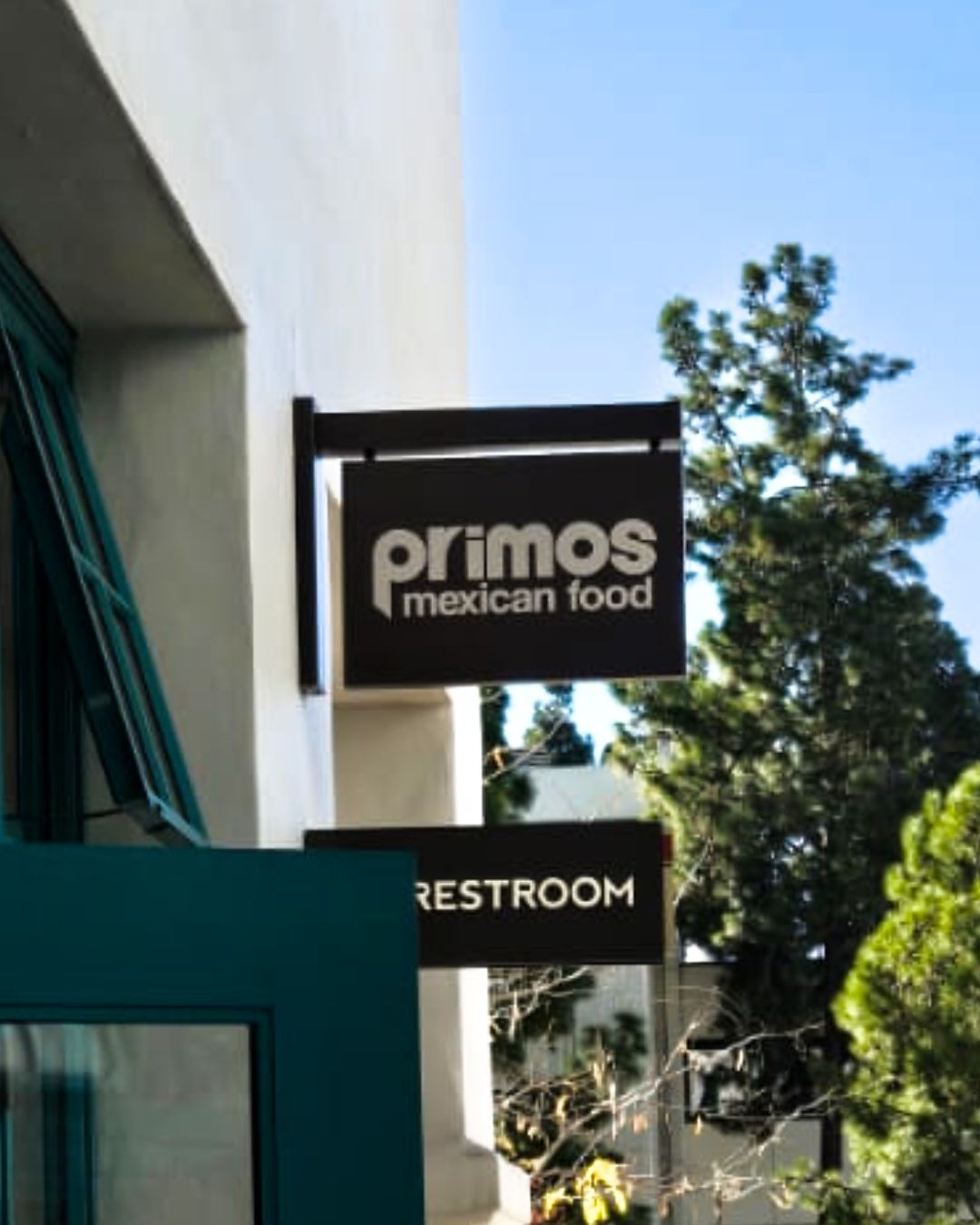 Sign for Primos Mexican Food and restroom on a building exterior