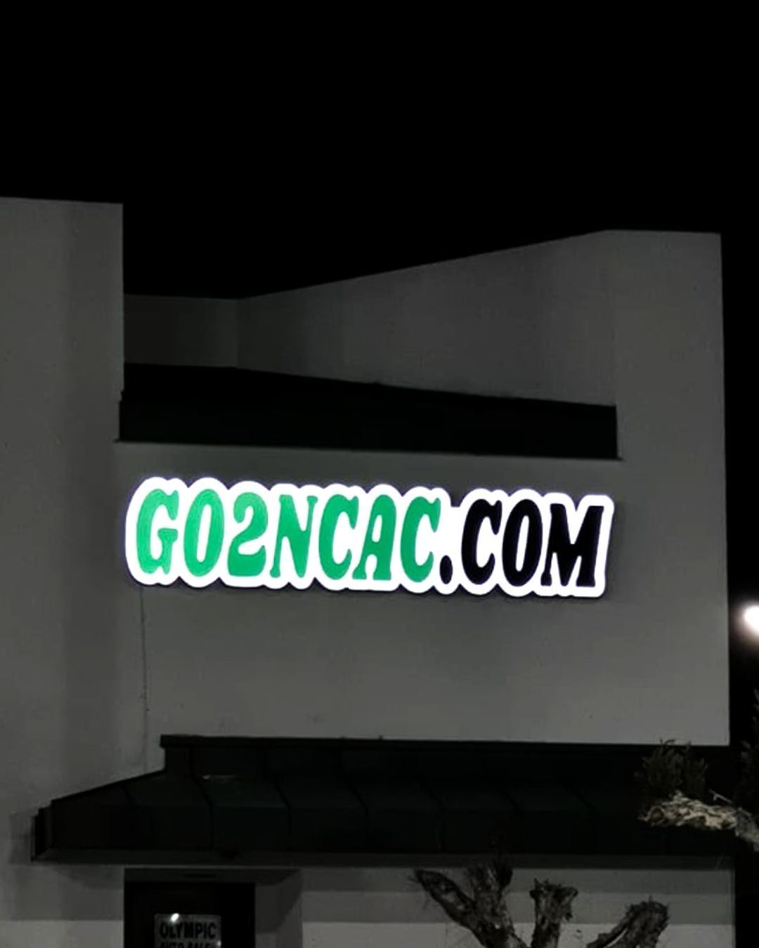 GO2NCAC.COM sign glowing green and white on a building at night