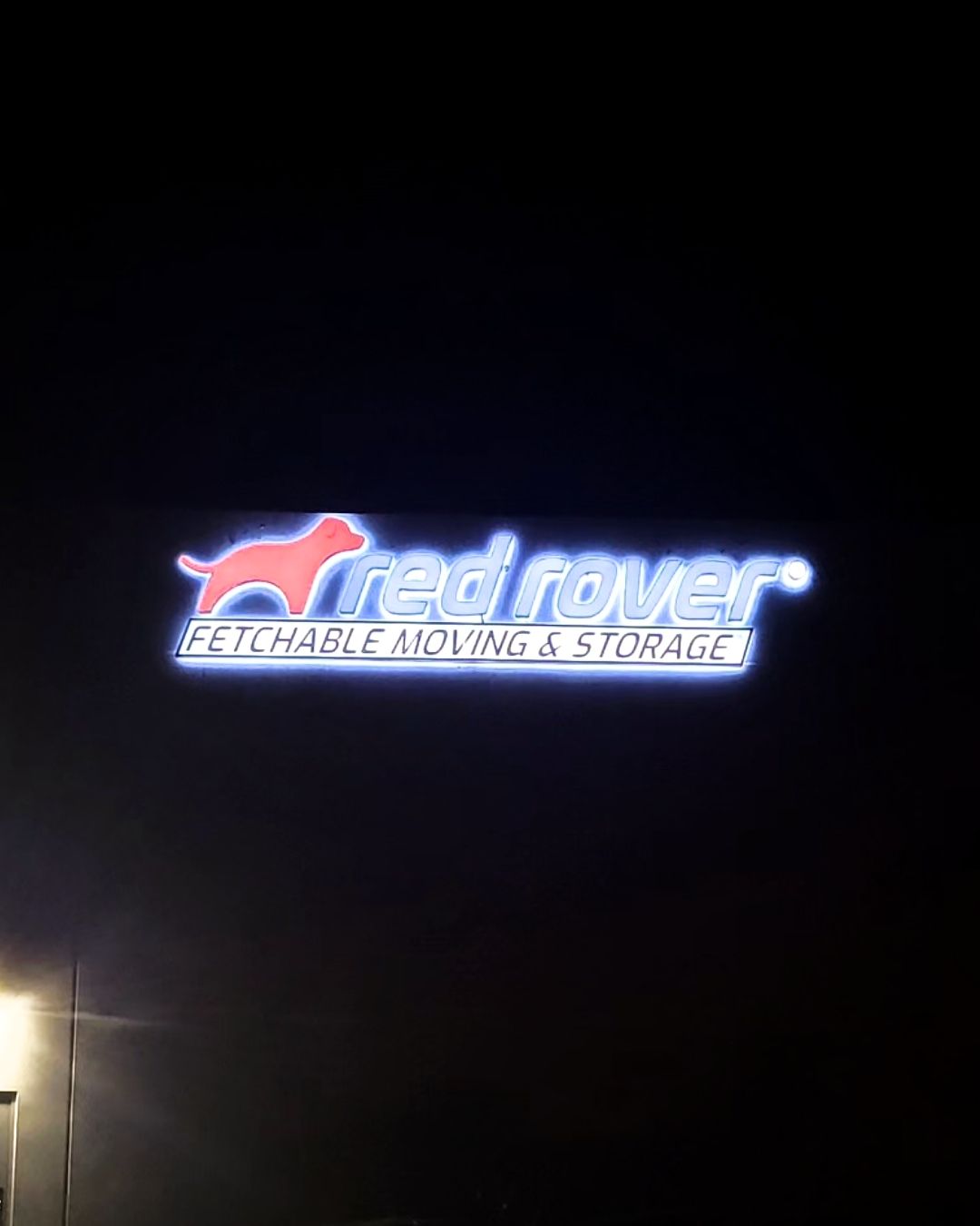 Red Rover self-storage sign glowing at night on a dark background
