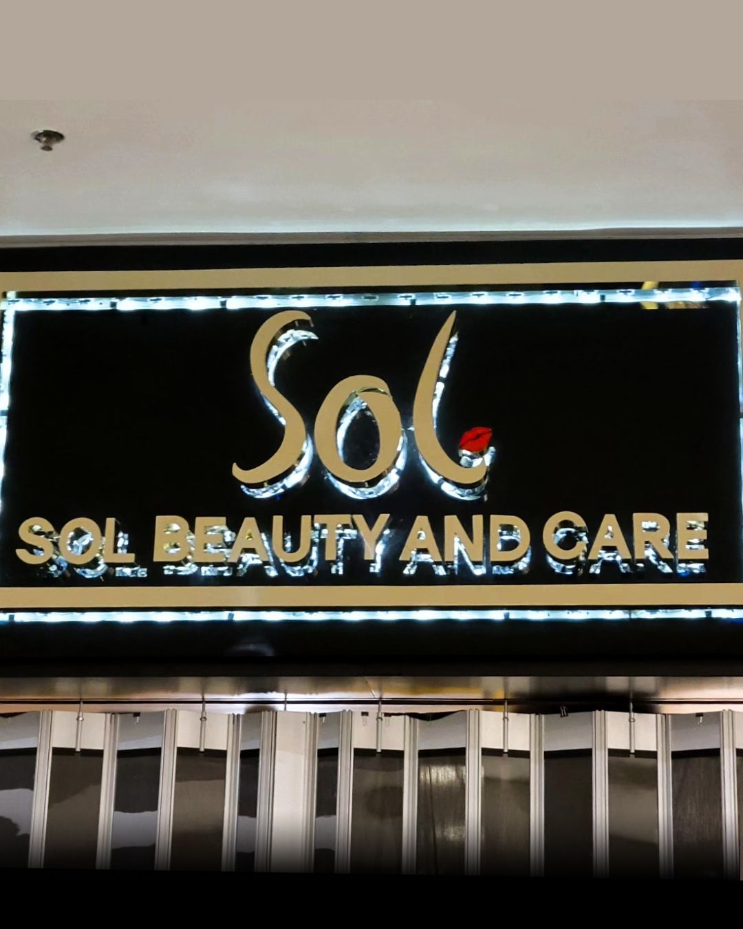 Black storefront sign reading Sol Beauty and Care in gold and red letters.