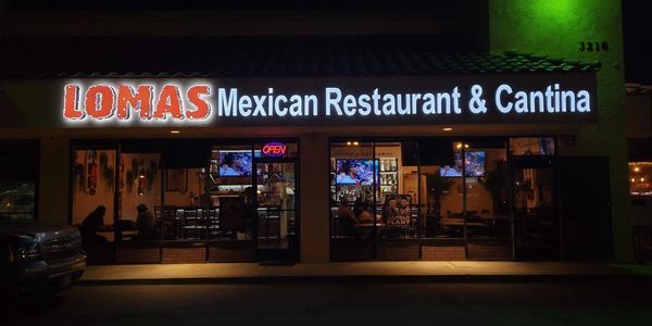 Lomas Mexican Restaurant & Cantina storefront at night, with illuminated sign and glass windows