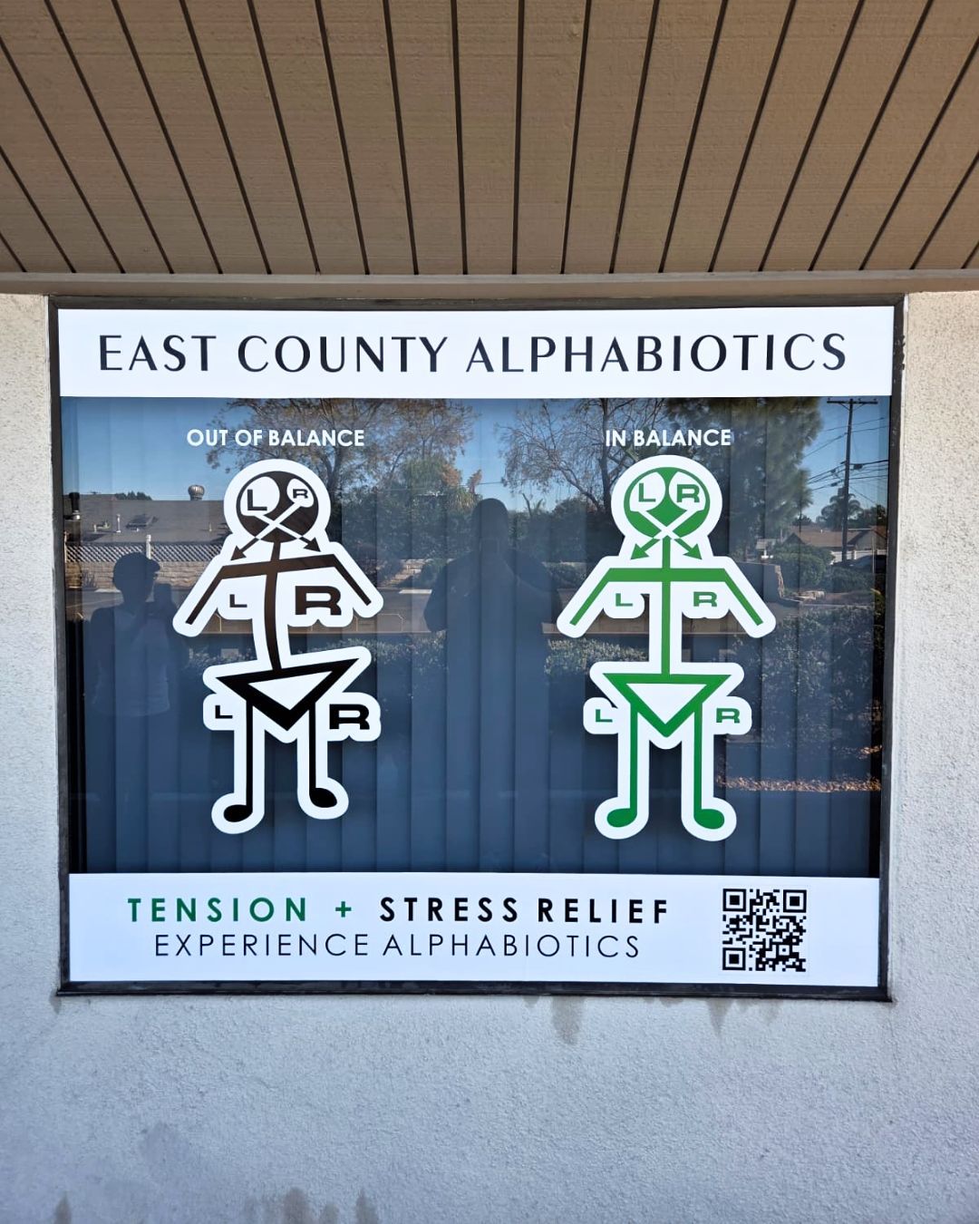 East County Alphabiotics sign with white and green stress-relief figures and a QR code