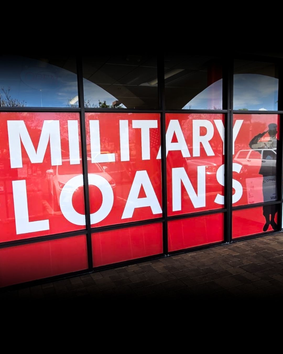 Red sign reading MILITARY LOANS in white text on a dark storefront display