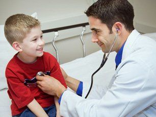Doctor checking the lungs of young boy