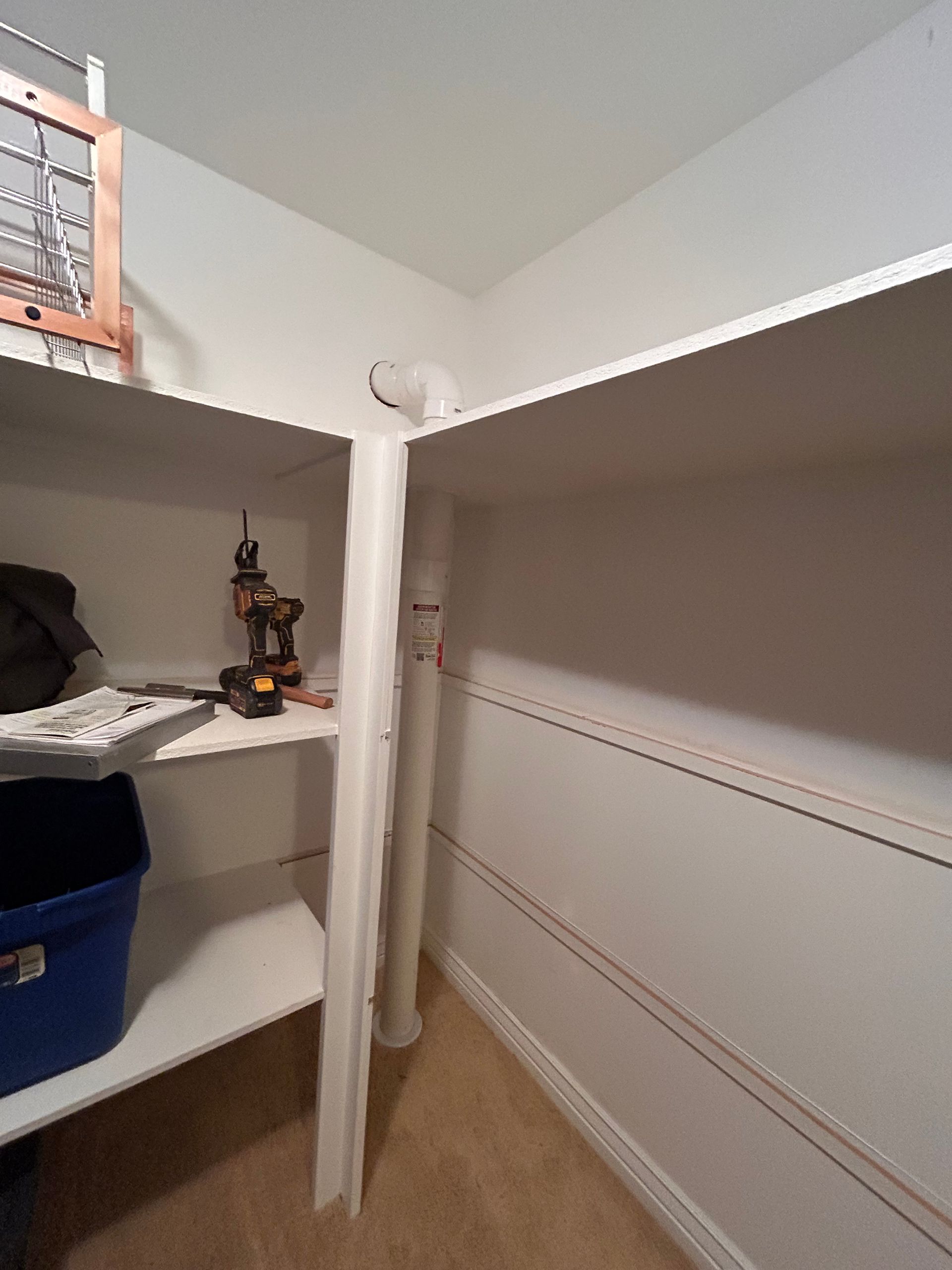 Empty white closet shelf with a blue bin and a small toy on the left side.