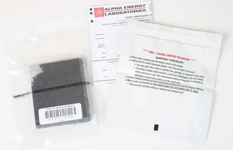 Black electronic component in a plastic pouch beside two white instruction sheets on a white surface