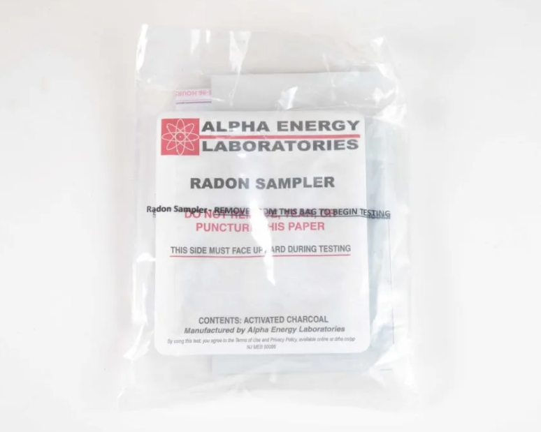 Clear plastic bag labeled “Alpha Energy Laboratories Radon Sampler” on a white background