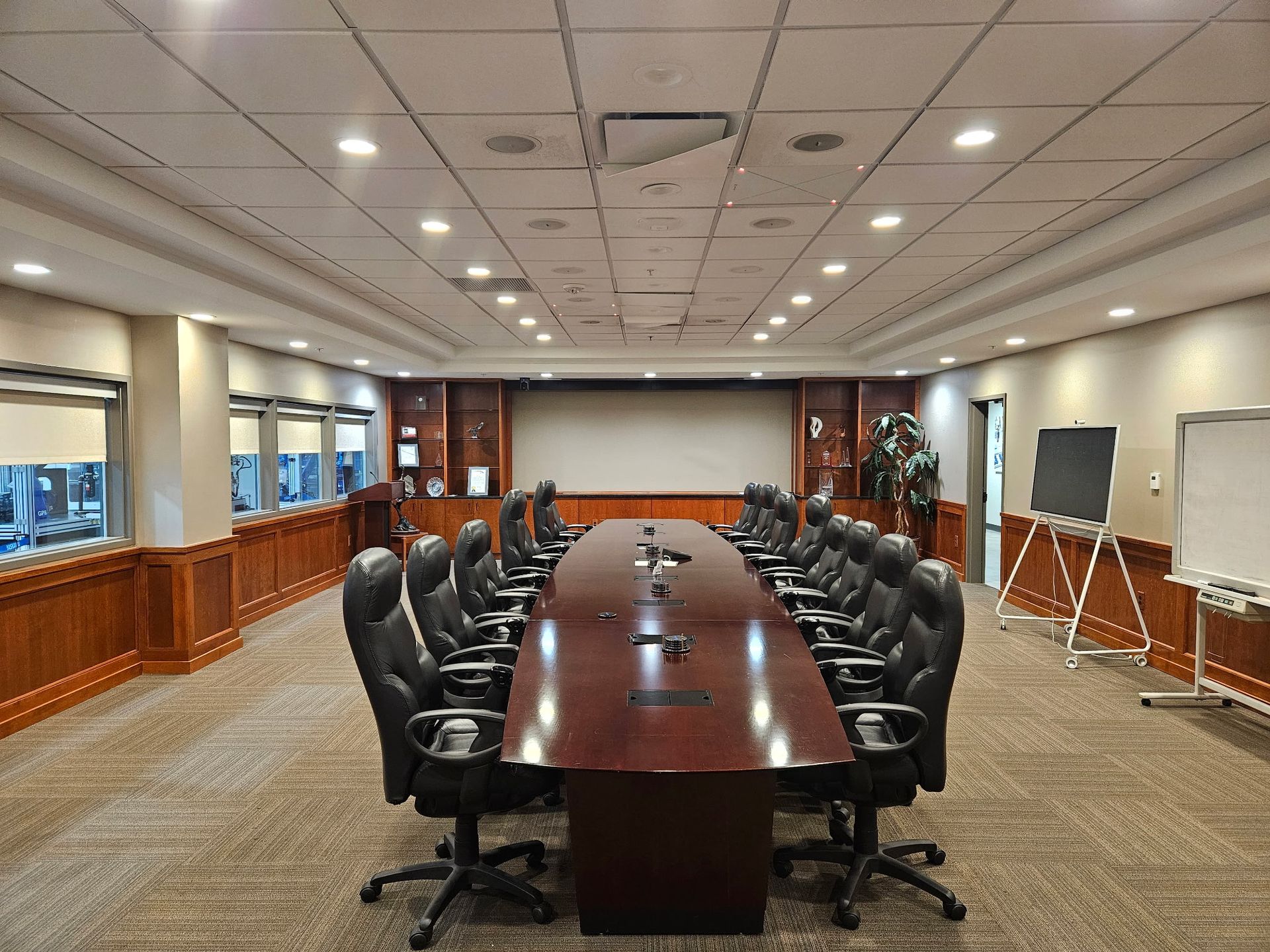 A large conference room with a long table and chairs.