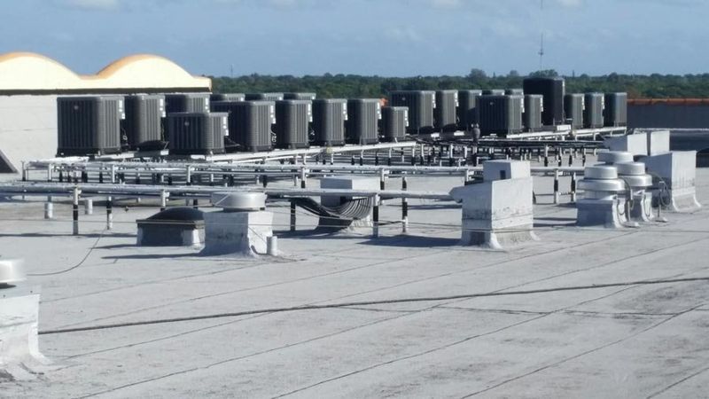 Commercial rooftop with multiple HVAC units and ductwork.
