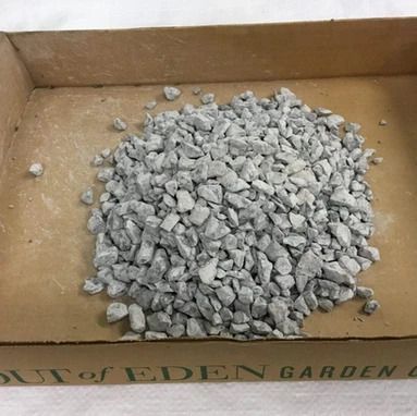 Gray gravel in a cardboard tray labeled 