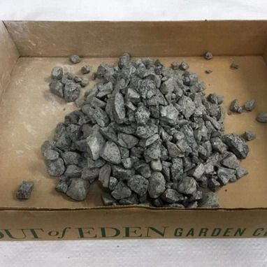 Gray rocks in a cardboard box labeled 