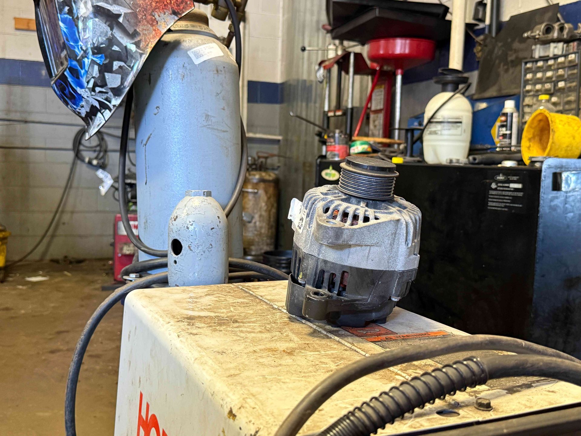 Workshop bench with a dusty black electric motor, cord, and tools in the background