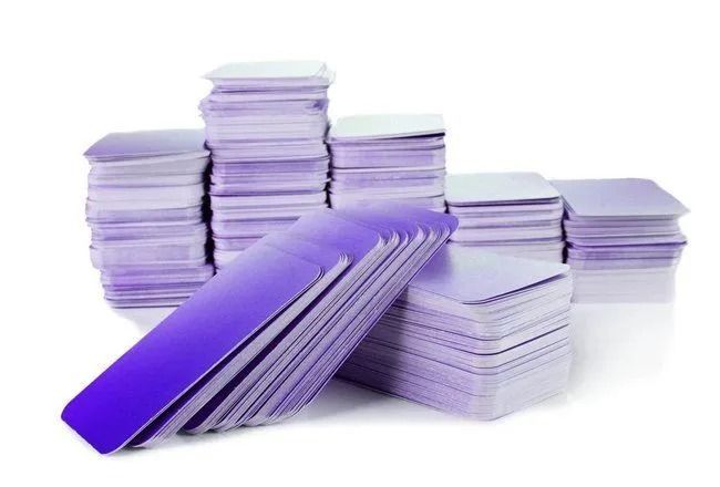 Stacks of purple and white index cards, with one stack fanned open in front