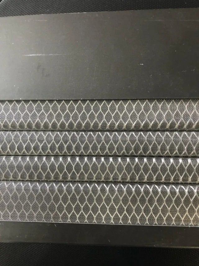 Black air filter with several layers of honeycomb mesh.