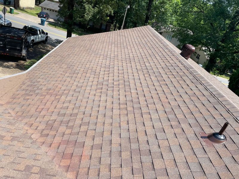 Brown asphalt shingle roof, with a few vents, on a residential building.