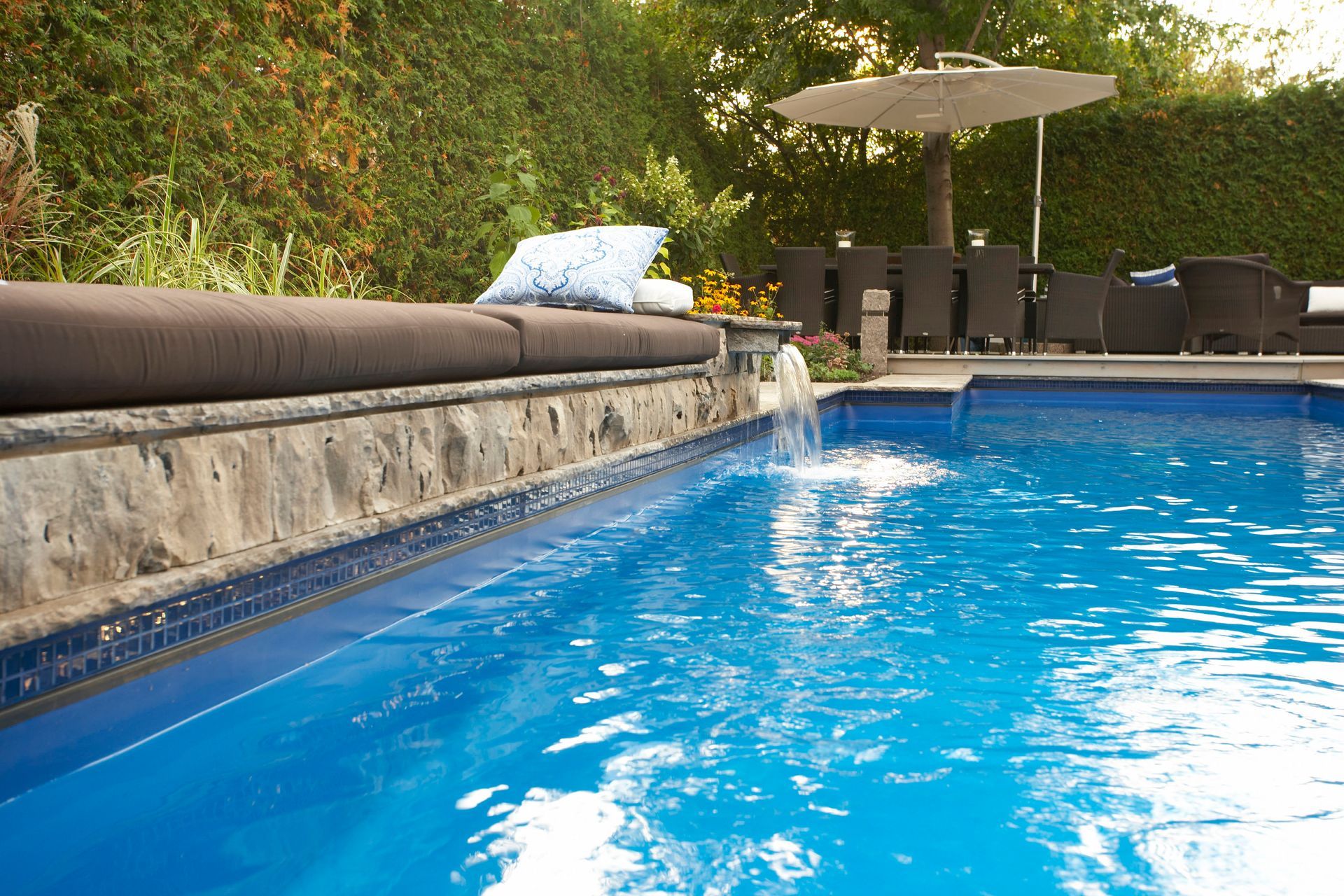 A swimming pool with a fountain in the middle of it