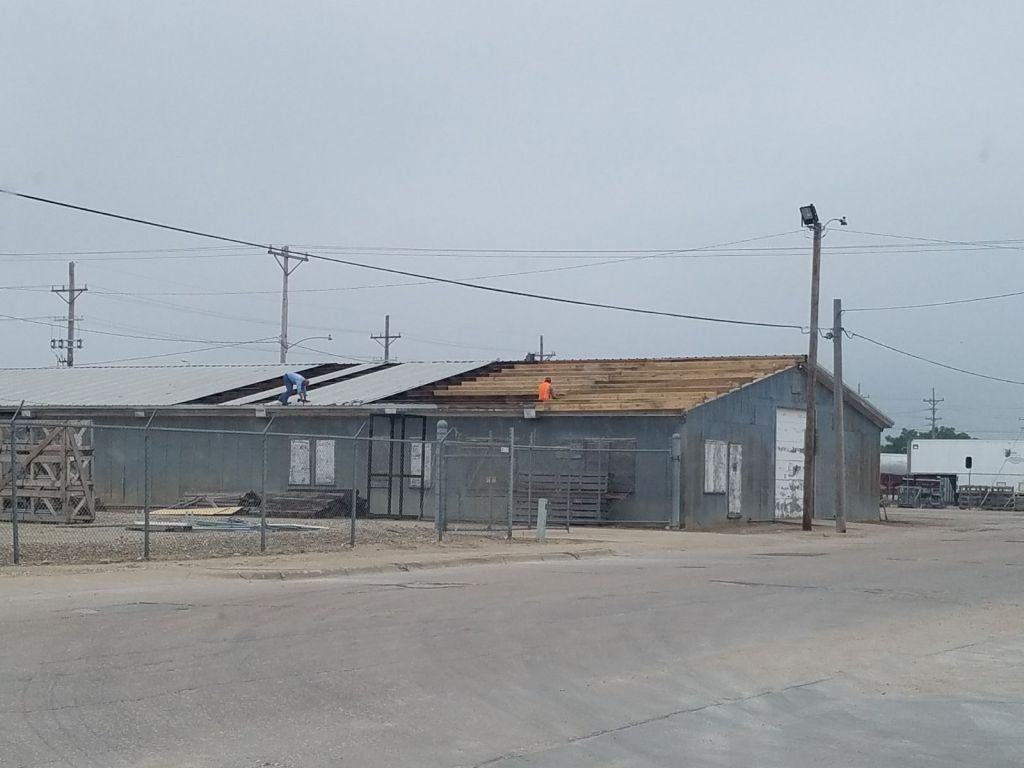 A fenced in area with a few buildings in the background
