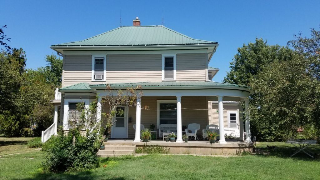 A house with a green roof and a porch