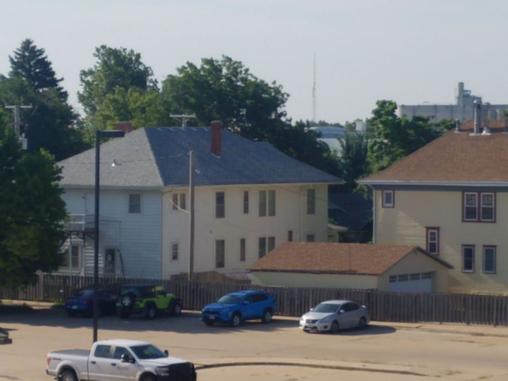 A white truck is parked in front of a house