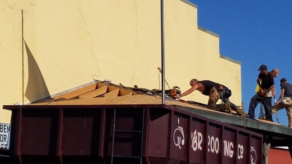 A group of men are working on the roof of a building