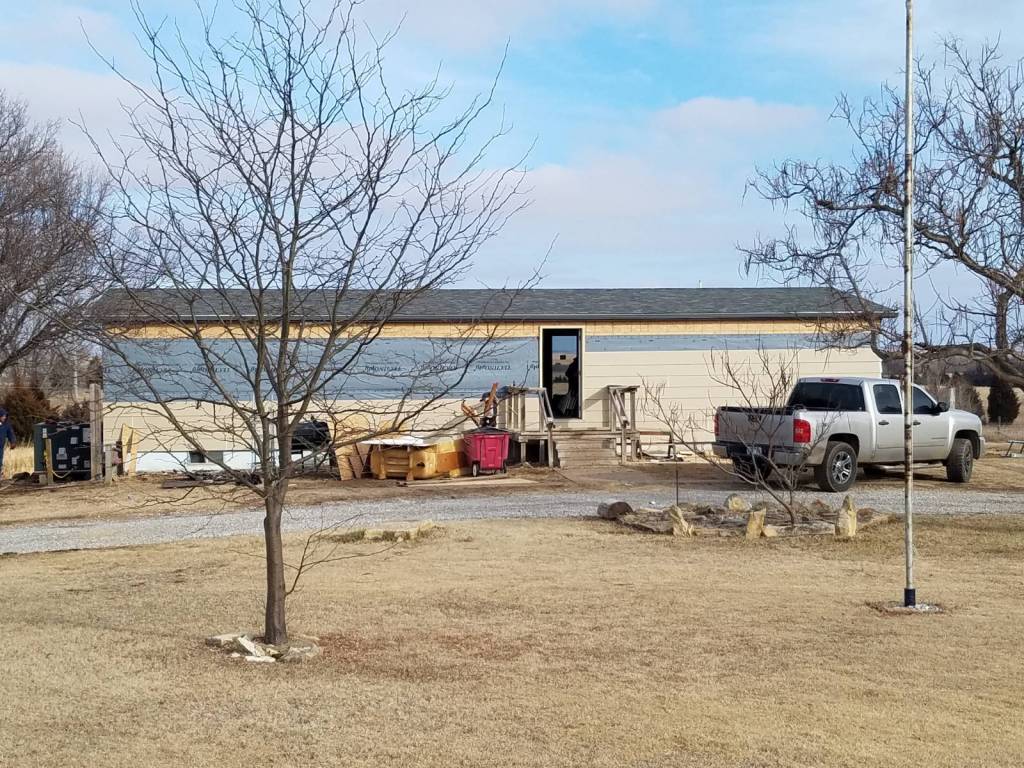 A white truck is parked in front of a house.