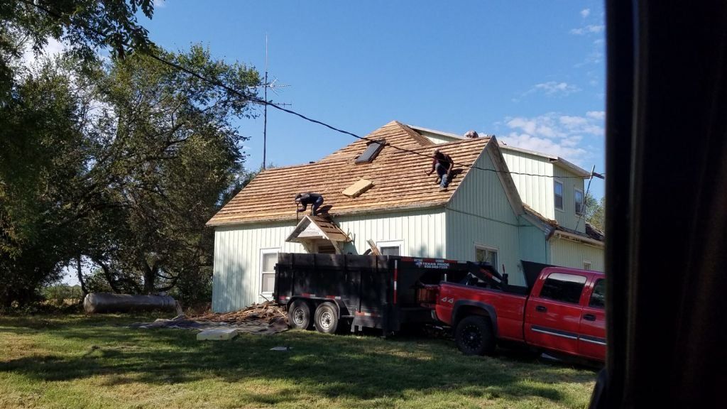 A red truck is parked in front of a house that is being remodeled.