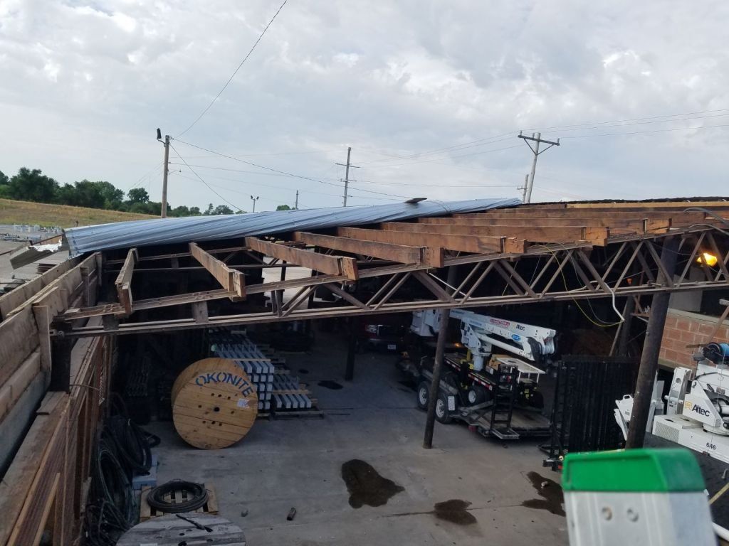A warehouse with a roof that has been damaged by a storm