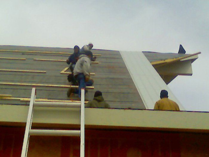 A group of men are working on the roof of a building