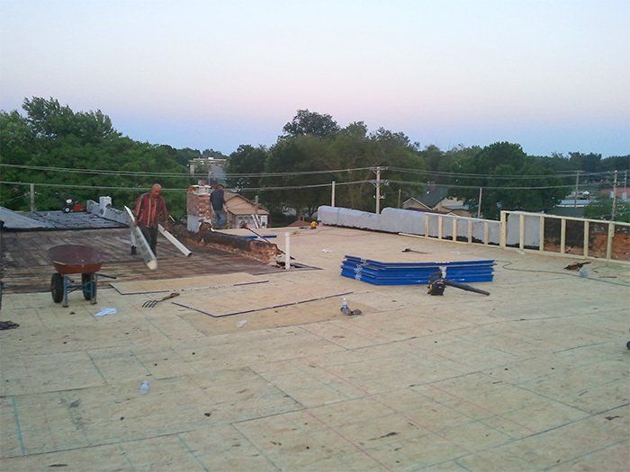A man is working on the roof of a building