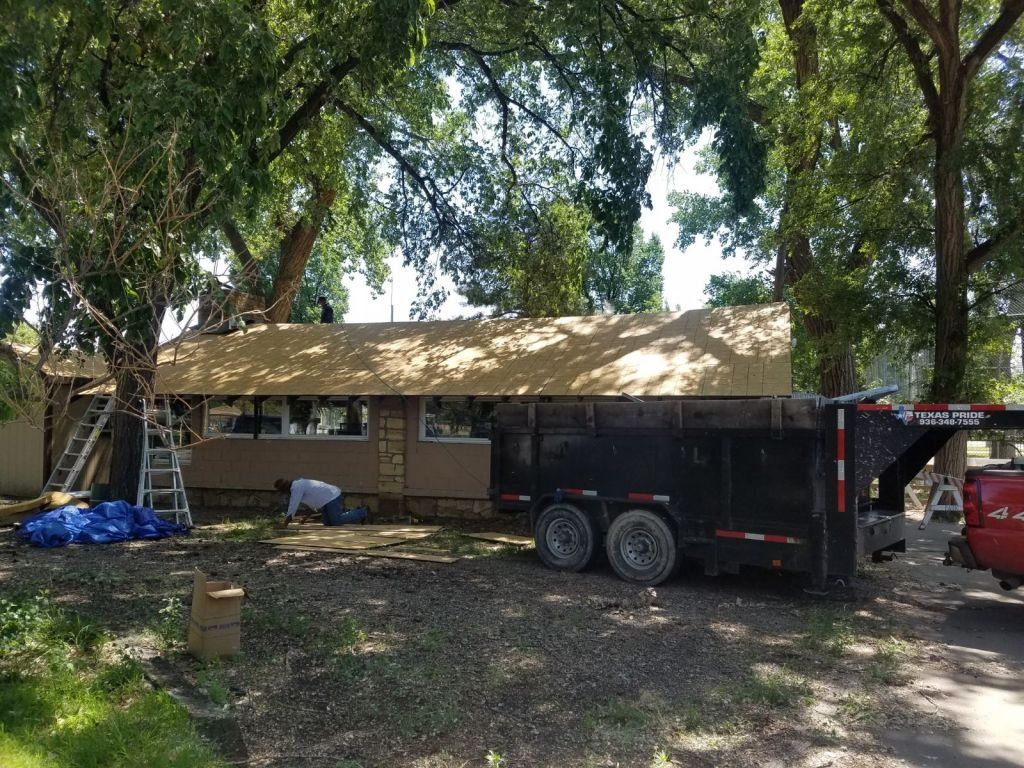 A trailer is parked in front of a house under construction.