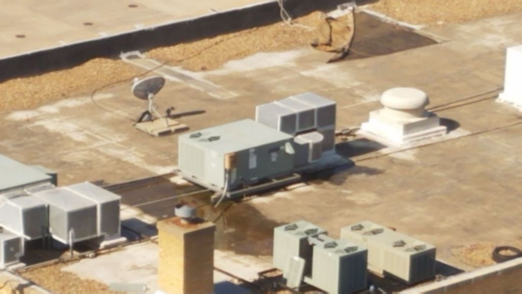 An aerial view of a rooftop with a satellite dish on it