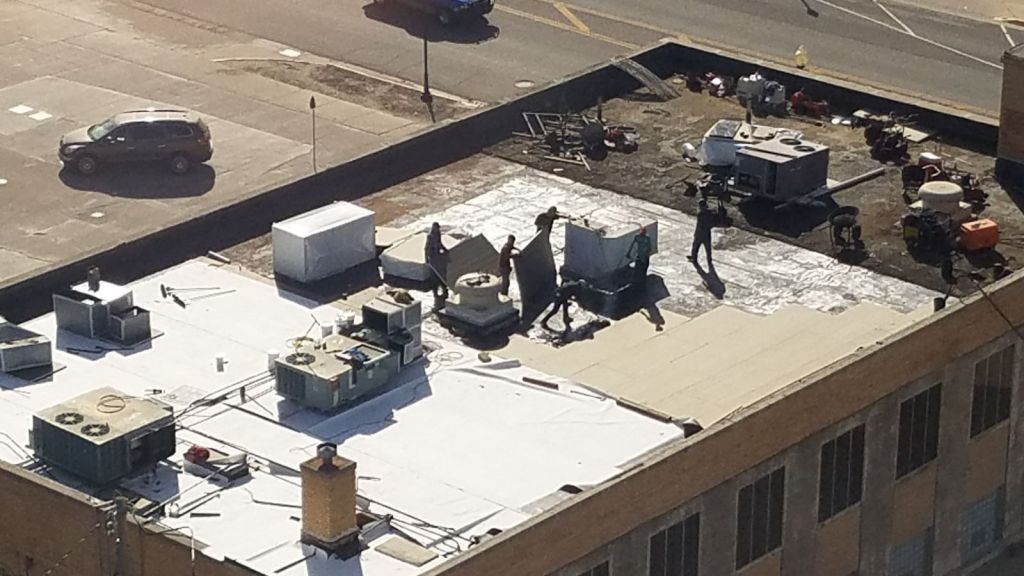 A group of people are standing on the roof of a building.
