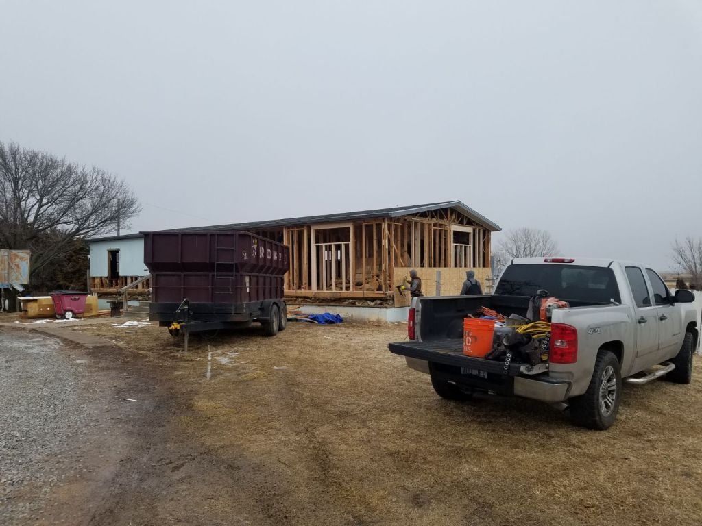 A truck is parked in front of a mobile home under construction.