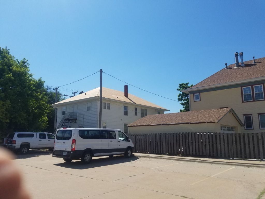 A white van is parked in front of a building