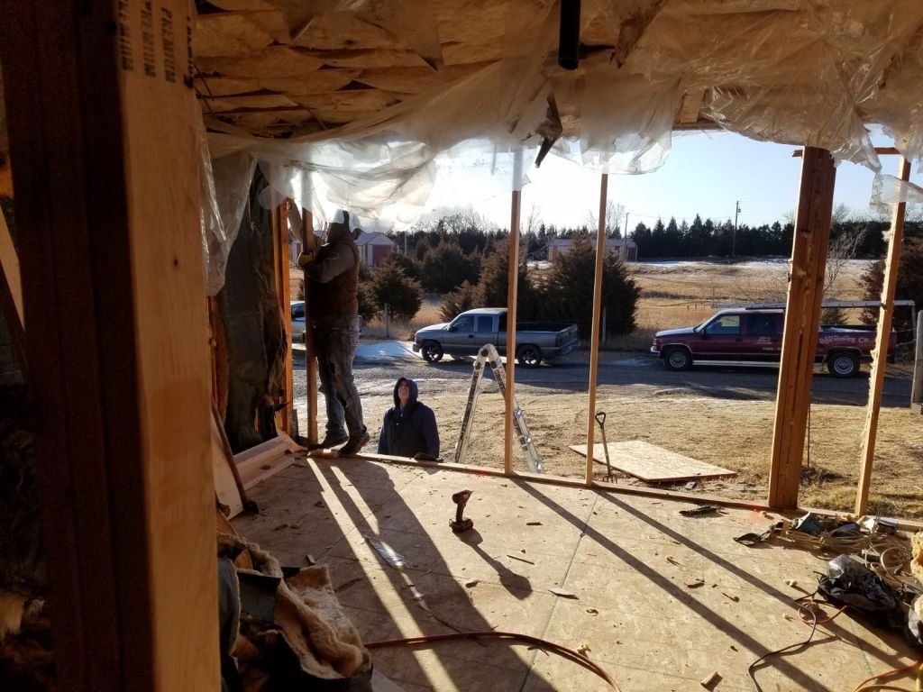 A man is standing in the middle of a building under construction.