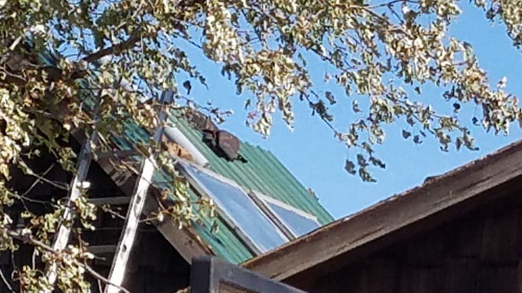 A ladder is hanging from the roof of a building.