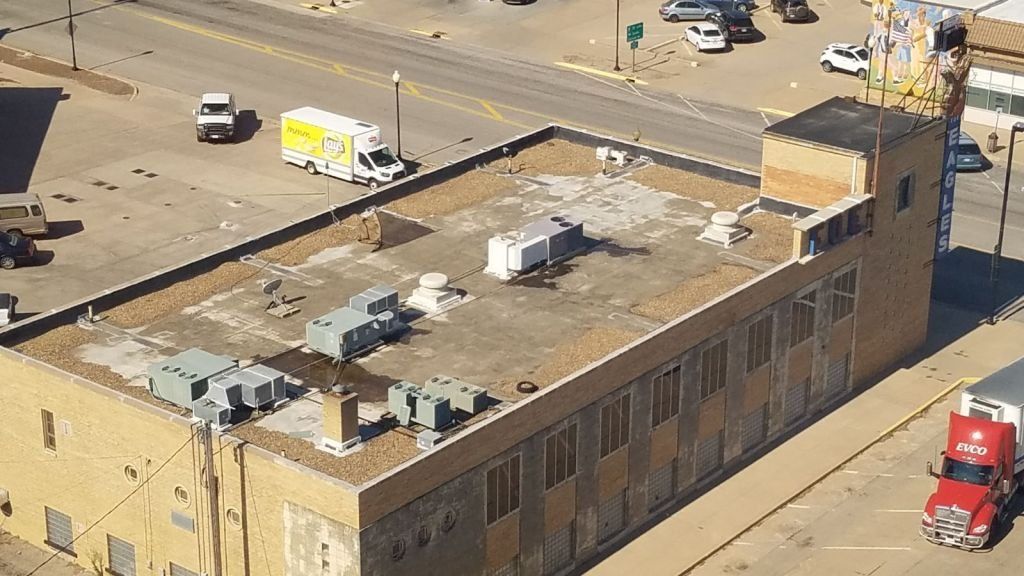 An aerial view of a large building with a red truck parked in front of it.