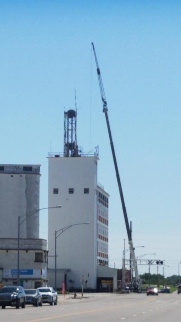 A large white building with a crane on top of it