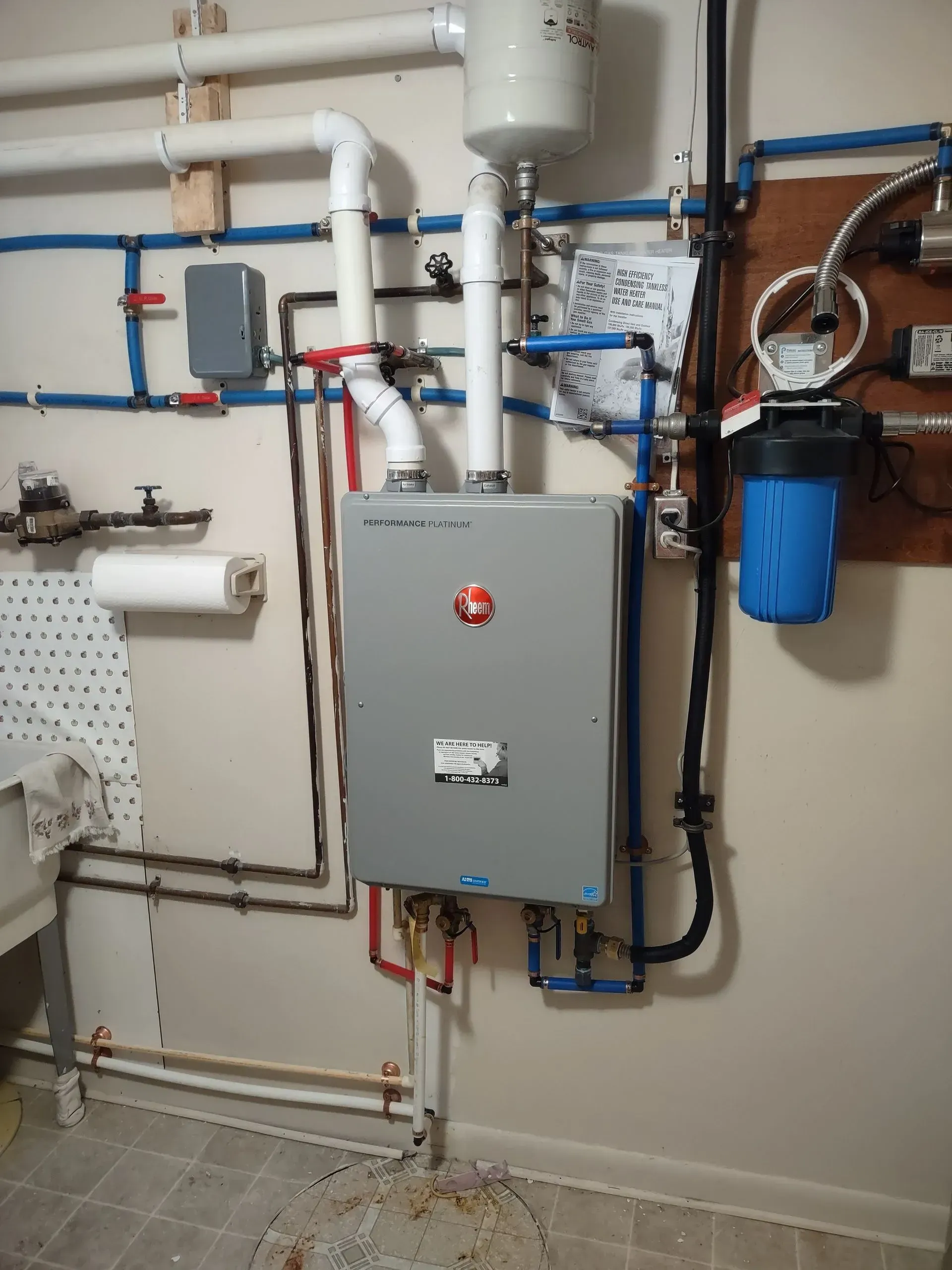 A room with a lot of pipes and a box on the wall