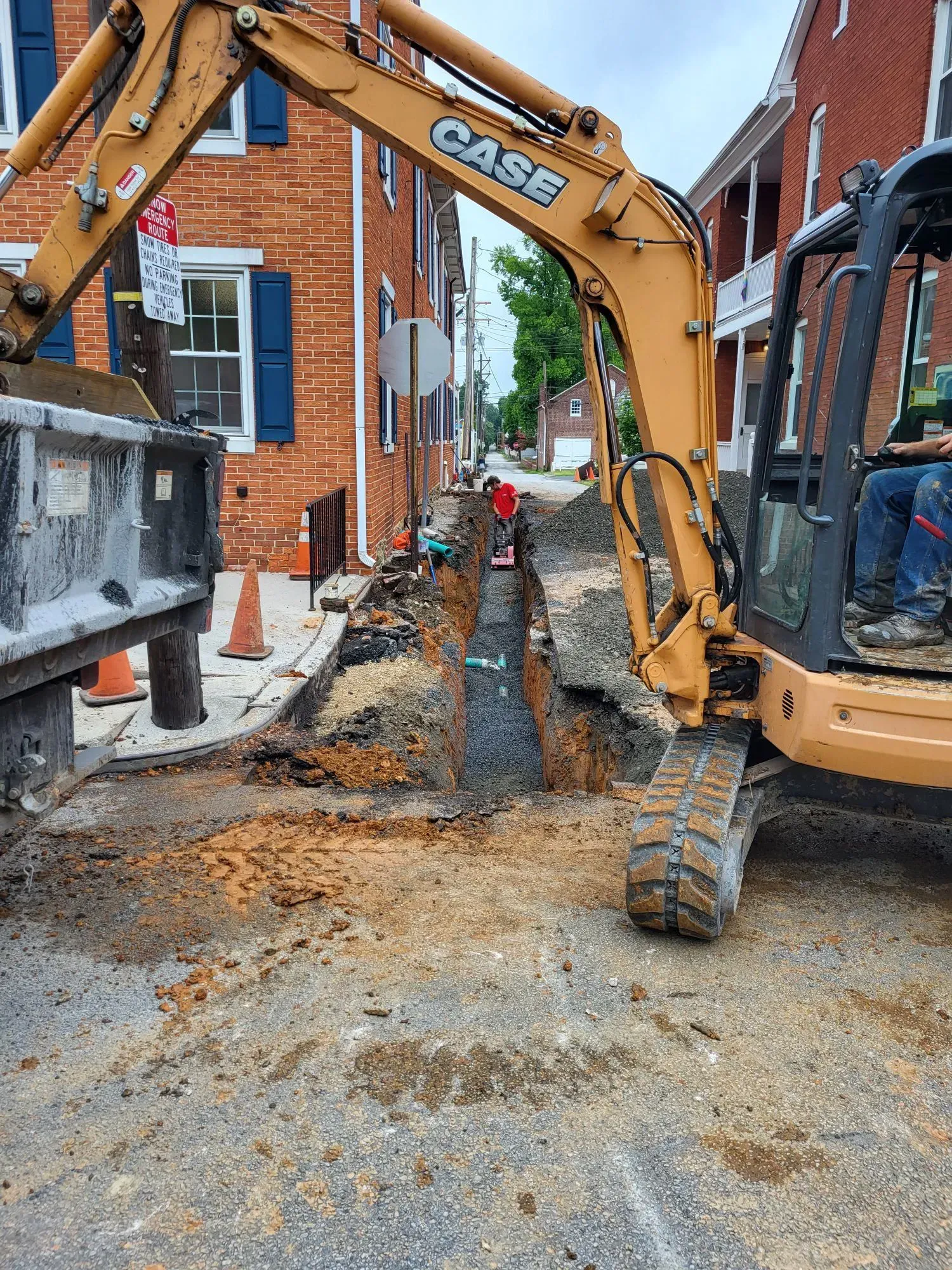 A yellow case excavator is digging a hole in the ground.
