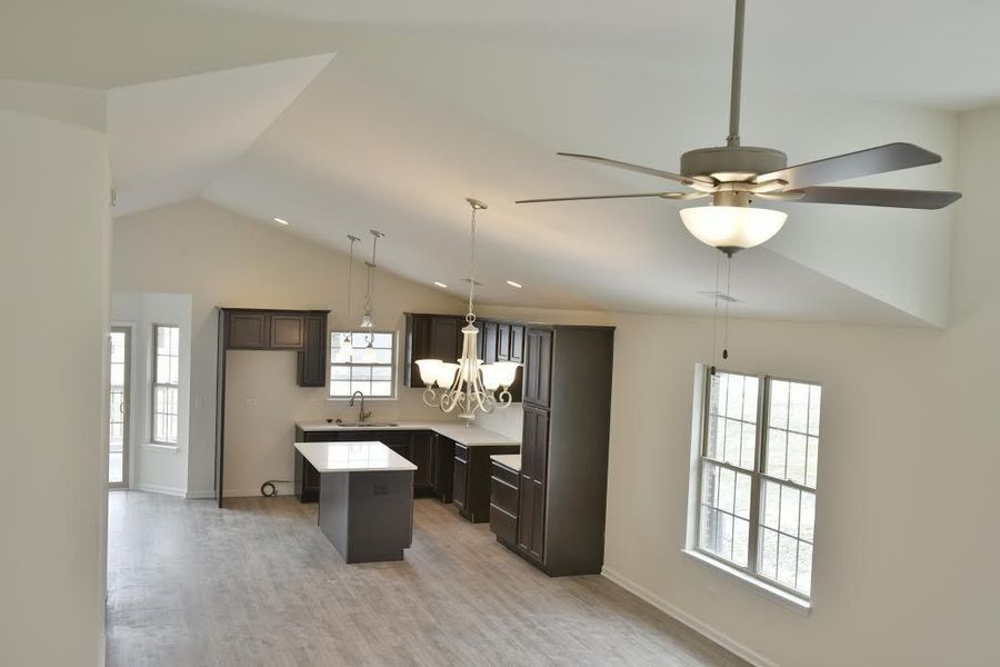 High-angle view of a modern kitchen with dark cabinets, a white countertop, and a ceiling fan.