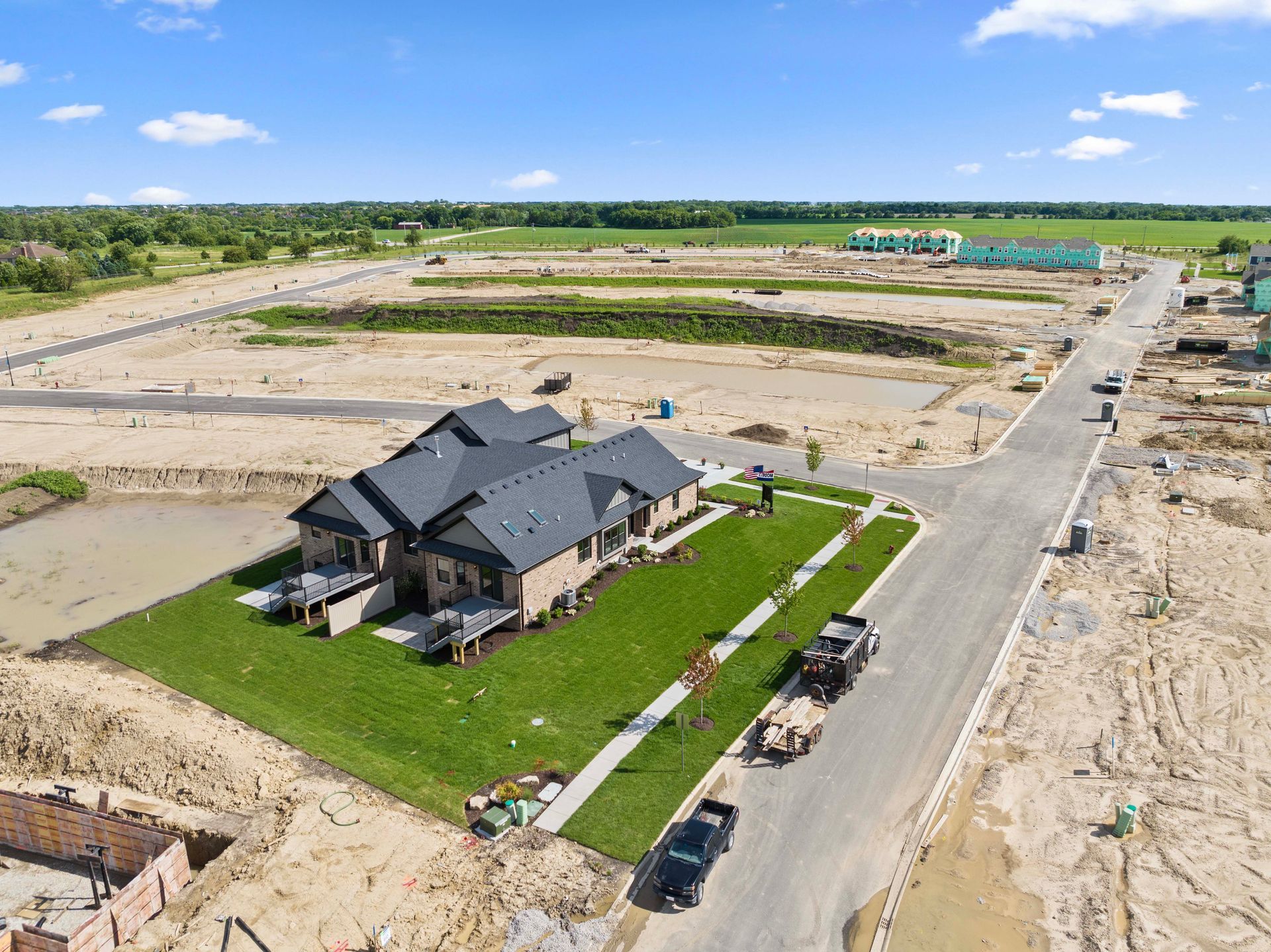 Aerial view of a new house under construction in a cleared suburban development.