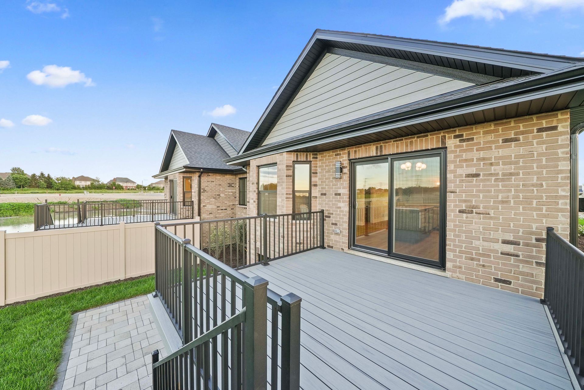 Modern brick house with fenced backyard deck and sliding glass doors