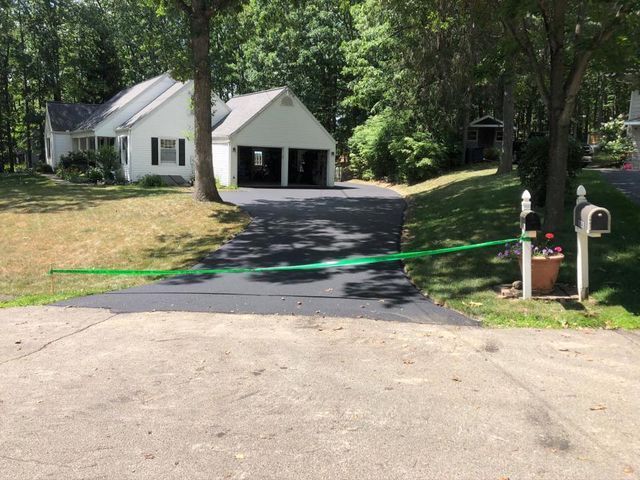 A house with a driveway and a mailbox in front of it