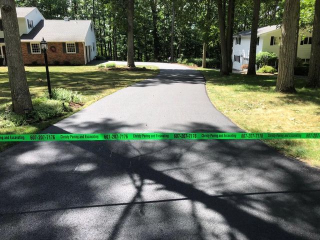 A driveway with a green tape that says ' do not enter ' on it